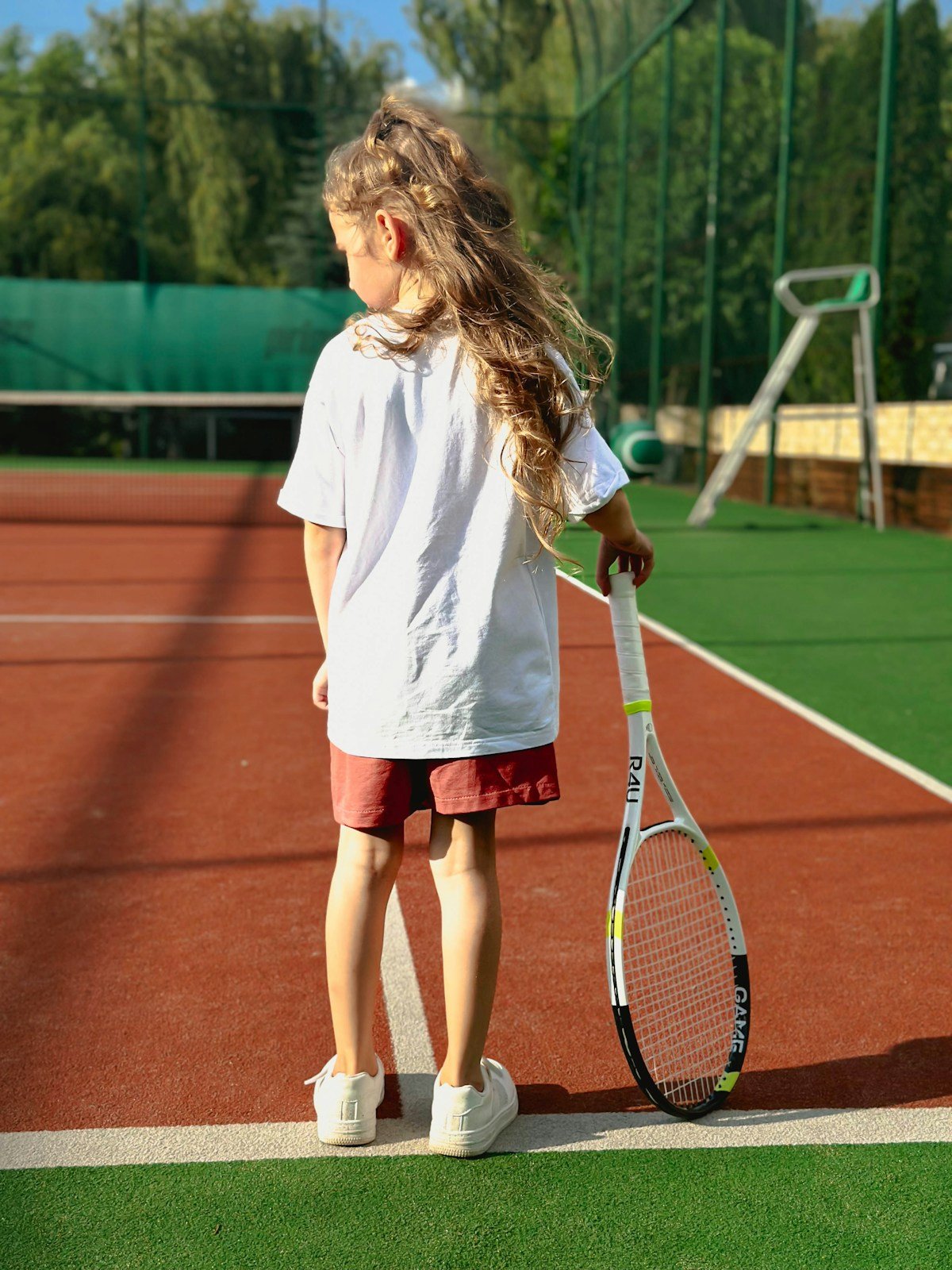 Enfant qui apprend le padel avec une raquette junior