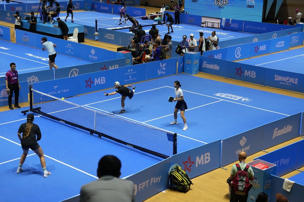 Joueurs s'affrontent lors d'un tournoi padel sur court bleu