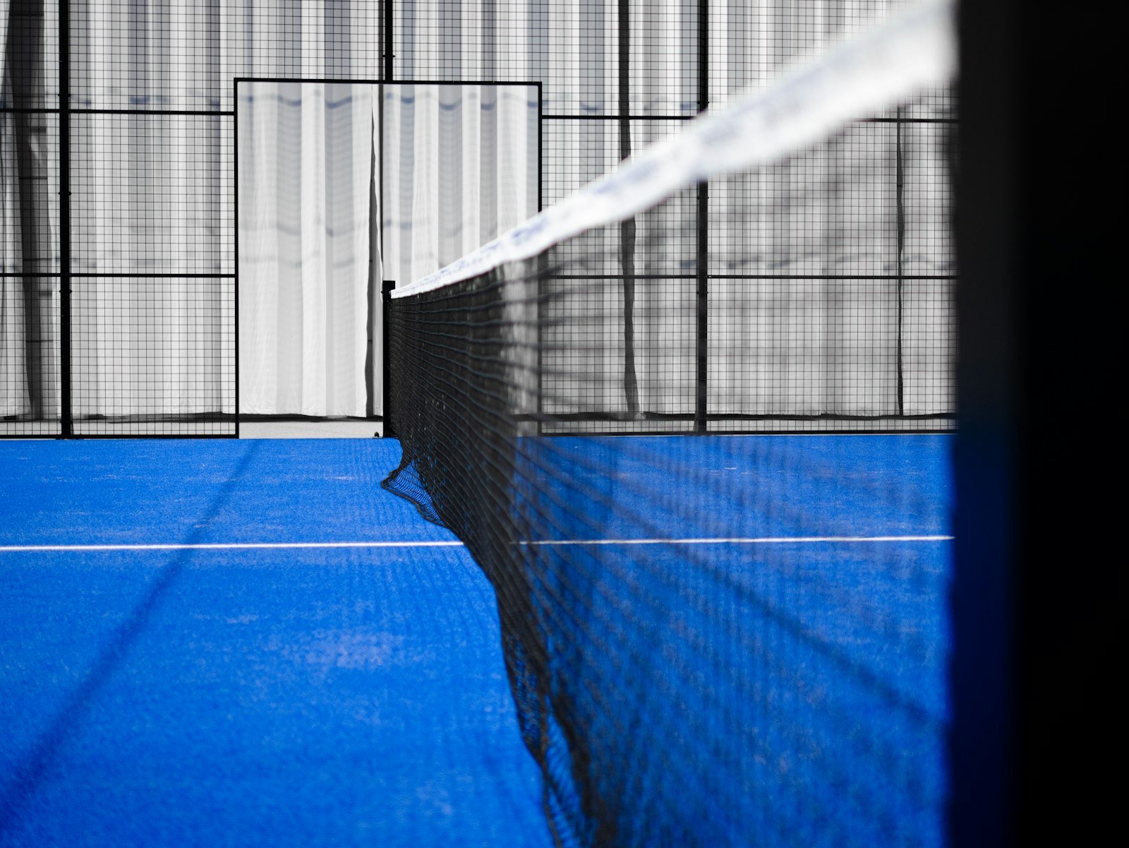 Sol bleu de terrain de padel avec ligne blanche - edito Padelrix sur raquettes pros