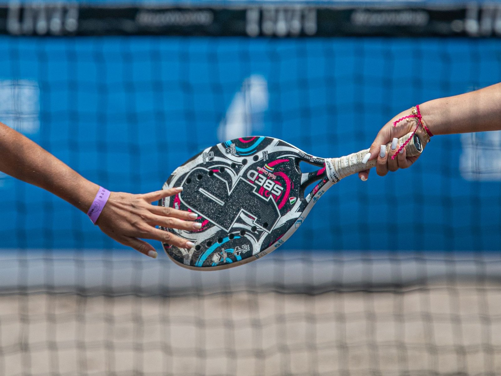Deux mains échangeant une raquette de padel Head