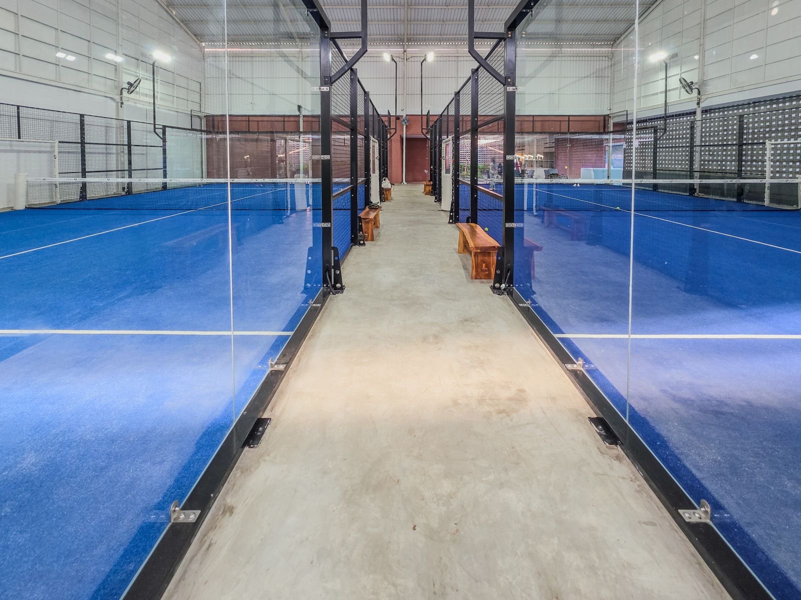 Allée centrale entre deux courts de padel couverts